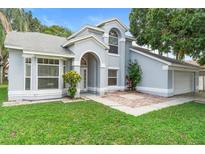 Charming gray home with manicured lawn, arched entryway, and lovely trees in a great neighborhood at 2708 Smithfield Dr, Orlando, FL 32837
