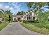 Stunning two-story home featuring stone accents, a red front door, and lush landscaping at 2770 Red Wing Vlg, Deland, FL 32720