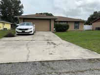Cozy single-story home with a well-maintained lawn, two-car garage, and lengthy driveway at 2875 Delrose N Dr, Lakeland, FL 33805