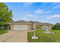Charming single-Gathering home featuring a well-manicured lawn, complemented by a decorative fountain and brick facade at 2880 Boyd Ct, Deltona, FL 32738