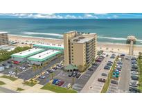 Aerial view of a beachfront condo building with ample parking and ocean views, perfect for coastal living at 3647 S Atlantic Ave # 7C, Daytona Beach, FL 32118