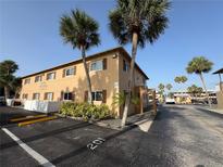 Tan two-story apartment building featuring palm trees and convenient parking at 411 N Halifax Ave # 208, Daytona Beach, FL 32118