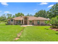 Charming single-story brick home with a well-manicured lawn and inviting entryway, blending classic style with outdoor appeal at 43350 Natchez St, Deland, FL 32720