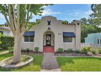 Charming stucco home with a beautiful front yard, walkway, and well-maintained landscaping at 441 N Julia Ave, Deland, FL 32720