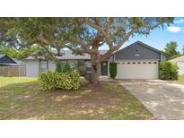 Charming single-Gathering home featuring a lush front yard with mature trees and a welcoming two-car garage at 510 Apollo Ave, Deltona, FL 32725