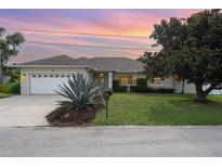 Charming single-story home boasts a two-car garage and well-manicured lawn with mature landscaping at 5445 Turton Ln, Port Orange, FL 32127