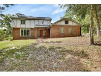 Two-story brick home featuring a red front door and a well-maintained yard at 658 Westchester Dr, Deland, FL 32724