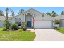 Charming single-Gathering home with a well-manicured lawn and an American flag at 824 Casterton Cir, Davenport, FL 33897