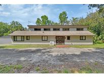 Unique home exterior with a blend of modern and traditional elements, under a bright blue sky at 910 Braddock Rd, Enterprise, FL 32725