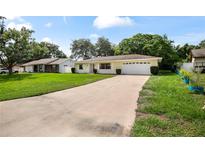Charming single-story home with yellow paint, attached garage, and a long driveway at 952 N Fairbairn Dr, Deltona, FL 32725