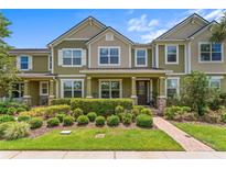 Charming two-story townhouse featuring a well-manicured lawn and an inviting front porch at 10460 Burrows St, Orlando, FL 32832