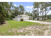 Charming single-story home with a large front yard and an attached two-car garage at 1094 Lolita St, Orange City, FL 32763