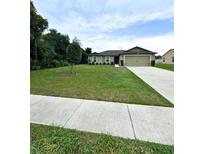 Charming single-story home boasts a well-manicured lawn, neutral exterior, and an attached two-car garage at 1115 Adirondack St, Deltona, FL 32725