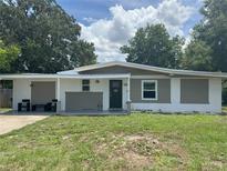 Charming one-story home with a manicured lawn and inviting front porch seating at 1215 N Boston Ave, Deland, FL 32724