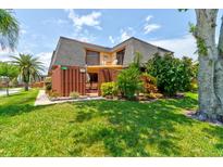 Charming condo featuring a well-manicured lawn, fenced front patio, and a small second story balcony at 122 Cedar Dunes Dr, New Smyrna Beach, FL 32169