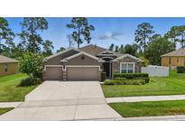 Charming single-story home with a three-car garage, stone accents, and manicured lawn at 1314 Lake Baton Dr, Deltona, FL 32725