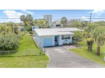 Charming light blue single-story home with a metal roof, a single-car garage, and a well-maintained lawn at 1420 N Grandview Ave, Daytona Beach, FL 32118
