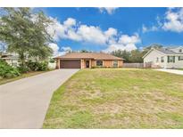 Charming single-story home with well-maintained lawn, long driveway, and a two-car garage at 1431 1St Ave, Deland, FL 32724