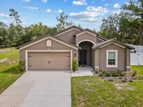 Charming single-story home featuring a two-car garage, well-manicured lawn, and a stylish front entrance at 1846 N Acadian Dr, Deltona, FL 32725