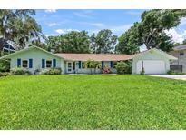 Charming single-story home with a lush green lawn and colorful exterior paint at 204 Rio Pinar Dr, Ormond Beach, FL 32174