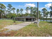 Fenced single story home with a screened in porch and lake views at 2620 Doyle Rd, Deltona, FL 32738
