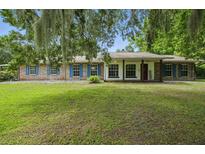 Charming single-story brick home featuring blue shutters and a lush green lawn at 2950 Ragis Rd, Edgewater, FL 32132