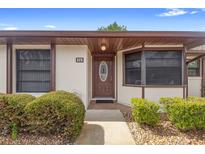 Inviting condo front door with decorative glass, manicured bushes, and brick accents on the walkway at 325 Homewood Ave # 10I, Debary, FL 32713