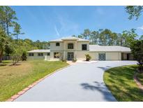 Spacious home featuring a long driveway, lush lawn, and well-maintained landscaping at 3428 Longleaf Rd, Ormond Beach, FL 32174