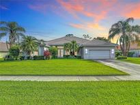 Beautiful one-story home with well-maintained landscaping, an attached garage, and a tile roof at 456 Sea Duck Dr, Daytona Beach, FL 32119