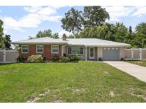 Charming single-story home with a well-manicured lawn, brick accents, and a metal roof at 502 W Hogle Ave, Deland, FL 32720