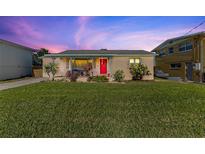 Charming home with a well-manicured lawn and a vibrant red front door at 505 Wisteria Rd, Daytona Beach, FL 32118