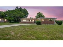 Charming single-story home featuring a brick facade and a well-maintained front yard at 5825 Forest Grove Blvd, Orlando, FL 32808