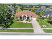 Beautiful one-story home with lush landscaping and a serene lake view creating an inviting curb appeal at 6083 Sabal Hammock Cir, Port Orange, FL 32128