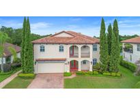 Two-story home with a tile roof, arched entry, and manicured landscaping at 762 Onyx Pkwy, Deland, FL 32724