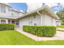 Charming home exterior with well-manicured lawn and attached two-car garage at 961 S Lakewood Ter # C, Port Orange, FL 32127