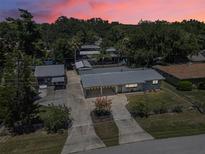 Beautiful single-Gathering home with a well-manicured lawn, mature trees, and a long driveway leading to a two-car carport at 1085 Indigo Rd, Ormond Beach, FL 32174