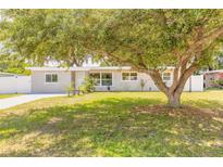 Charming single-story home featuring a well-maintained lawn and mature trees in a serene neighborhood at 118 N Sunland Dr, Sanford, FL 32773