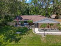 Charming home features manicured lawn, mature landscaping, and neutral exterior paint at 1516 Arrowhead Trl, Enterprise, FL 32725