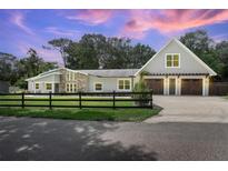 Charming home featuring a stone facade, wood garage doors, and a well-manicured lawn at 1620 20Th St, Orange City, FL 32763