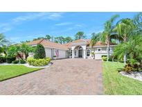 Stunning single-story home featuring a brick driveway, lush landscaping, and a welcoming entrance at 2825 S Asciano Ct, New Smyrna Beach, FL 32168