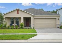 Charming single-Gathering home with a two-car garage, front porch and manicured lawn and garden at 317 River Front Way, Edgewater, FL 32141