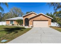 Charming single-story home showcasing a well-maintained lawn, two-car garage, and inviting front entrance at 413 Coventry Estates Blvd, Deltona, FL 32725