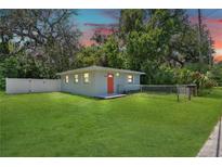 Charming single-story home with a well-manicured lawn, fenced yard, and bright orange front door at 528 Pine St, Daytona Beach, FL 32114