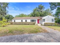 Charming single-story home with a well-maintained lawn and a vibrant red front door at 611 N Garfield Ave, Deland, FL 32724