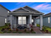 Charming single-story home with a well-manicured lawn and inviting front porch with chairs and landscaping at 614 Becklow St, Debary, FL 32713