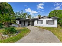 Charming single story home featuring mature landscaping and a curved driveway at 916 Kathy St, Daytona Beach, FL 32114