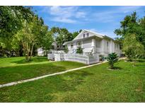 Charming home featuring a manicured lawn and a classic white picket fence, evoking a welcoming and picturesque curb appeal at 1056 Stevens St, Lake Helen, FL 32744