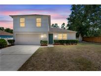 Charming two-story home with a well-maintained lawn, manicured shrubbery, and a two car garage at 1561 Randolph St, Deltona, FL 32725