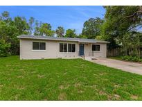 Charming single story home featuring a bright green lawn, refreshed exterior paint, and inviting blue door at 182 Grove St, Ormond Beach, FL 32174