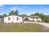 Charming single-story home showcasing a circular driveway and unique, decorative architectural details at 2080 Roseway Ave, Deltona, FL 32738